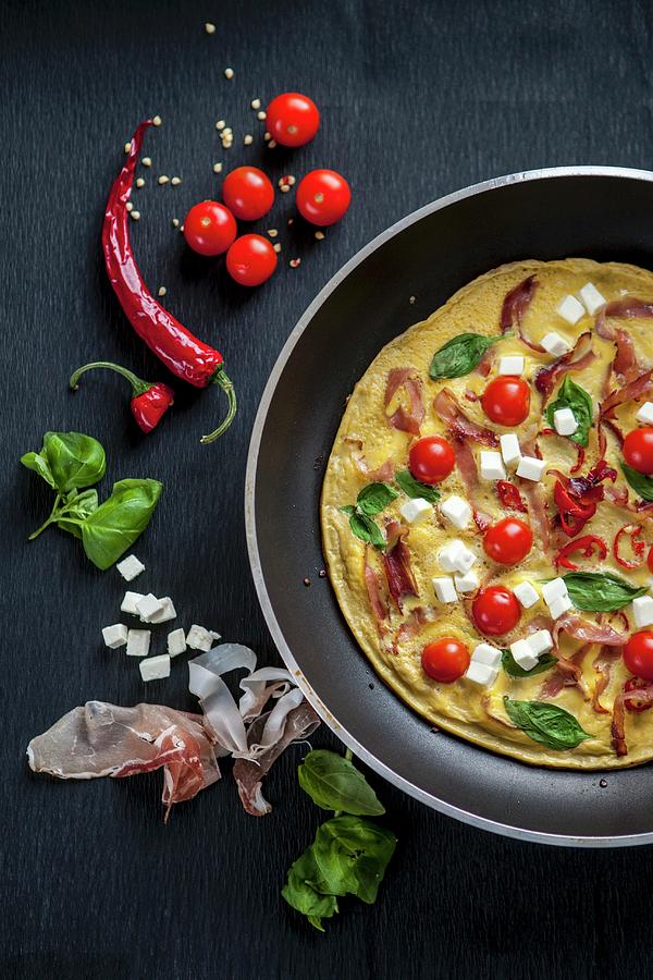 A Breakfast Omelette With Tomatoes, Feta Cheese, Ham And Basil #1 Photograph by Karolina Kosowicz