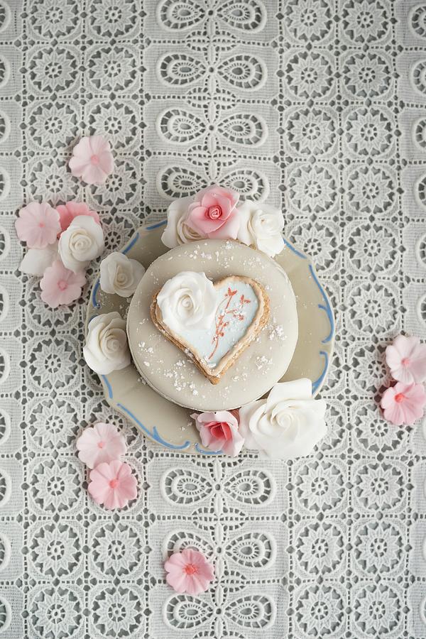 A Cake Decorated With Fondant Icing Sugar, Heart-shaped Biscuit And Sugar Roses #1 Photograph by Mandy Reschke