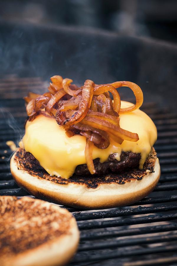 A Hamburger With Cheese And Toasted Onions On A Grill #1 Photograph by Eising Studio