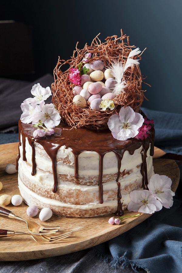 A Naked Sponge Cake Decorated With An Easter Nest, Chocolate Eggs And Blossoms #1 Photograph by Stacy Grant