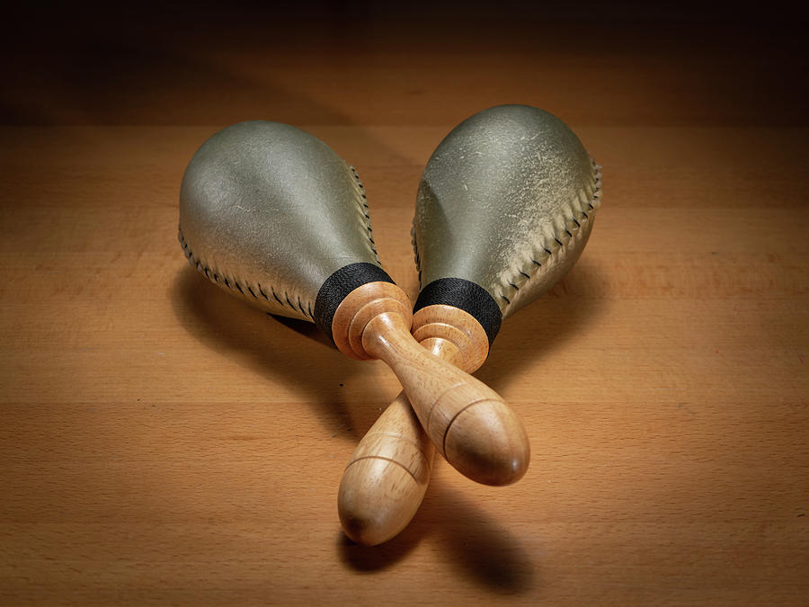 A Pair Of Rawhide Maracas Lying On A Wooden Table Photograph
