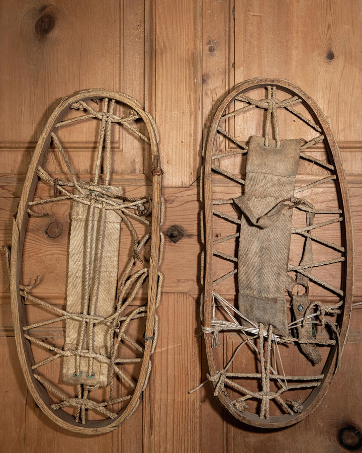 A Pair Of Very Old Snowshoes Hanging On A Wooden Wall Photograph