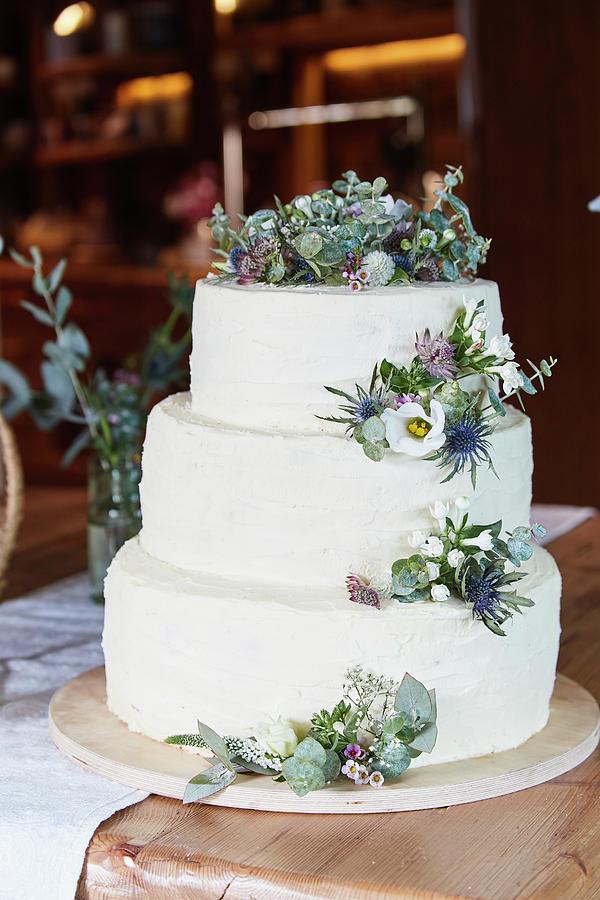 A Three-tier Wedding Cake Decorated With Flowers #1 Photograph by Brigitte Sporrer