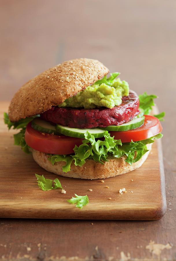 A Veggie Burger With A Beetroot Patty And Avocado Spread #1 Photograph by Olga Miltsova