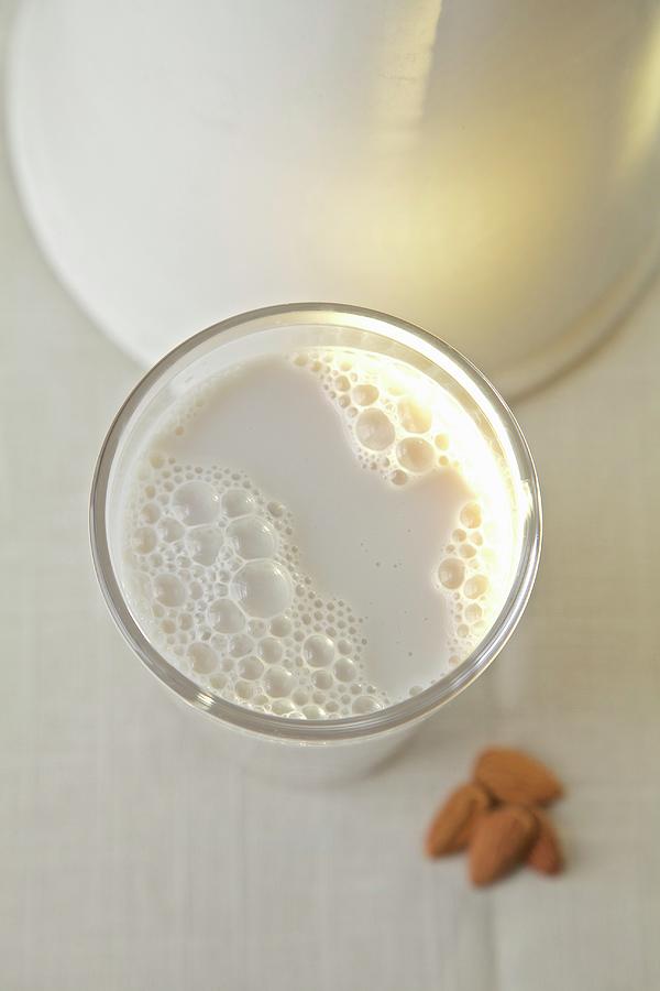 Almond Milk In A Glass In Front Of A White Jug #1 Photograph by Andre Baranowski