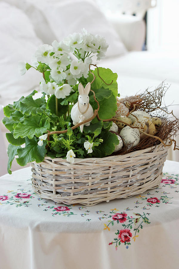 Basket With Primrose, Horned Violets, And Branches As An Easter Decoration With An Easter Bunny And Easter Eggs #1 Photograph by Angelica Linnhoff