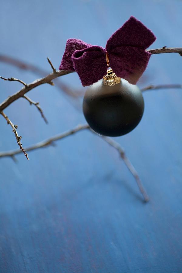 Black Christmas-tree Bauble With Felt Ribbon On Bare Branch #1 Photograph by Alicja Koll