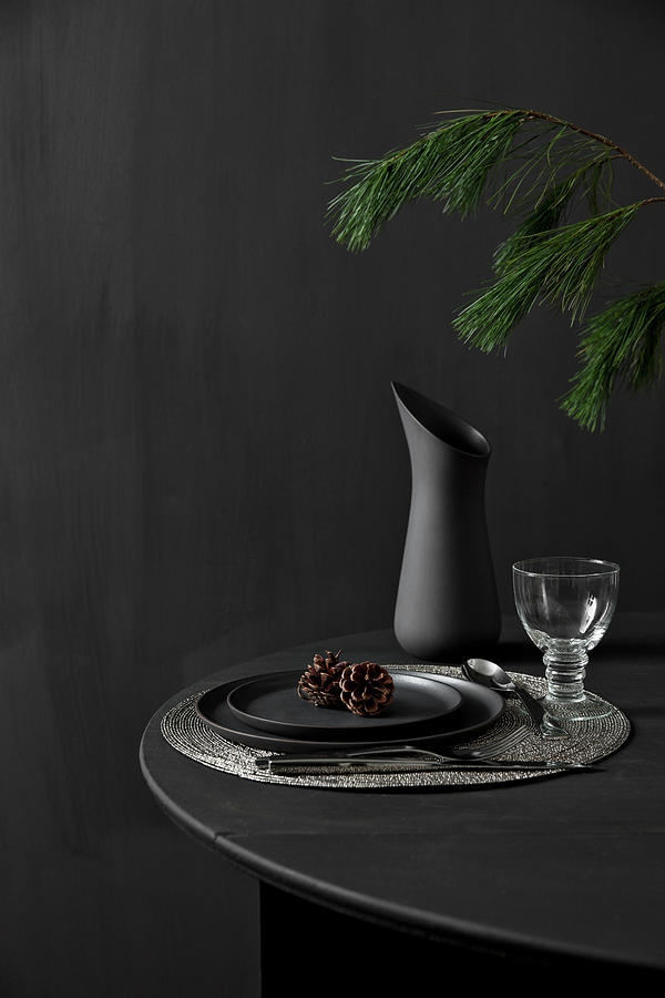 Black Table Set For Dinner And Decorated With Larch Branches Against Black Wall #1 Photograph by Lykke Foged & Morten Holtum
