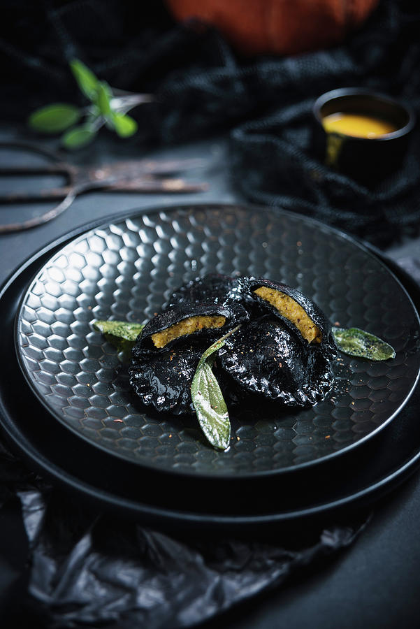 Black Vegan Ravioli dyed With Active Charcoal In Sage Butter Filled With Pumpkin Pure #1 Photograph by Kati Neudert