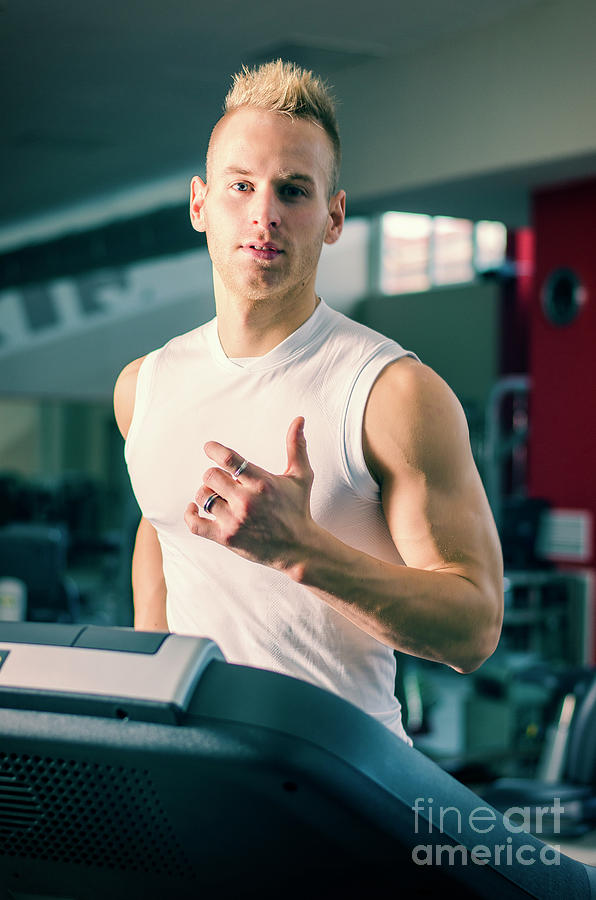 Handsome blond young man exercising pecs on gym equipment Fleece