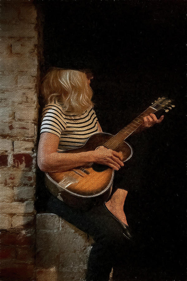 Blondie woman playing guitar sitting on a brick wall #1 Photograph by Dan Friend