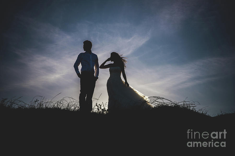 Bride and groom backlit in a sunset on the beach. #1 Photograph by Joaquin Corbalan