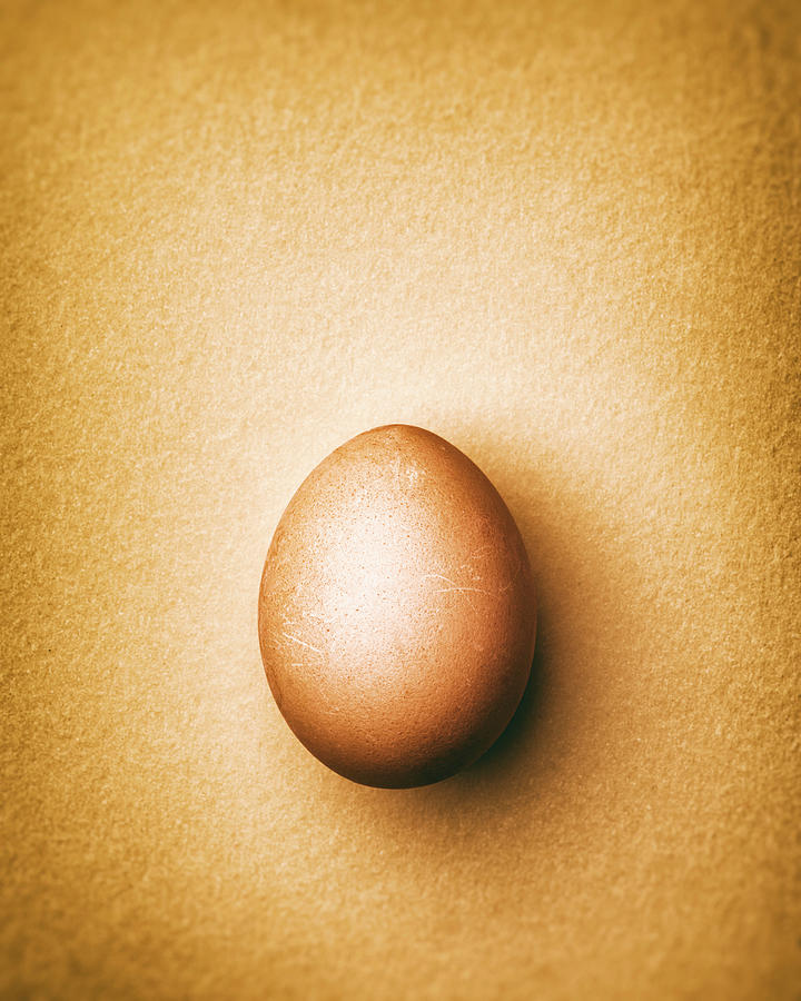 Brown Chicken Egg On A Light Orange Background #1 Photograph by Peter Rees