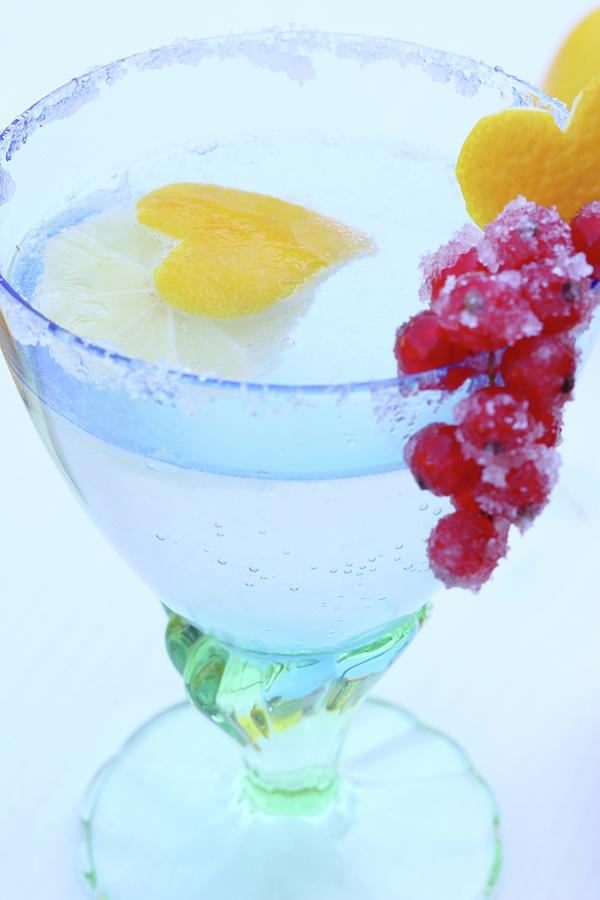 cold Duck Punch In A Glass With A Sugared Rim, Decorated With A Heart Made From Lemon Peel And With Candied Redcurrants #1 Photograph by Johanna Von Aesch