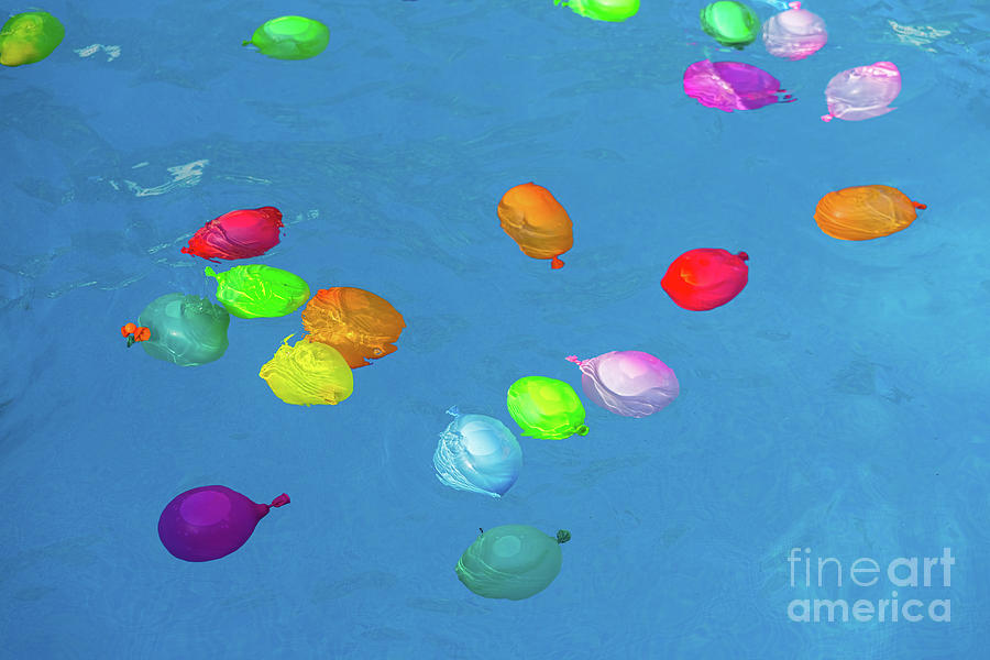 Colorful plastic water balloons floating in a pool to play on va #1 Photograph by Joaquin Corbalan