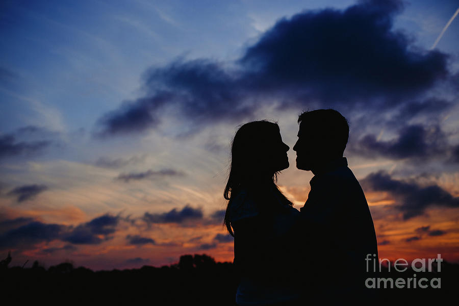 Couple with cloud sky backlight #1 Photograph by Joaquin Corbalan