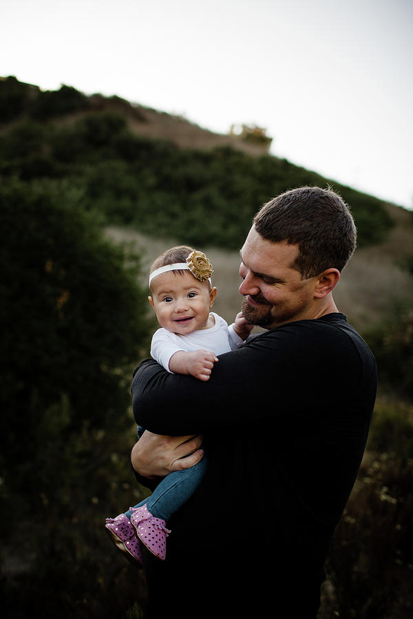Fall Photograph - Dad Hugging Infant Daughter As Baby Looks At Camera #1 by Cavan Images