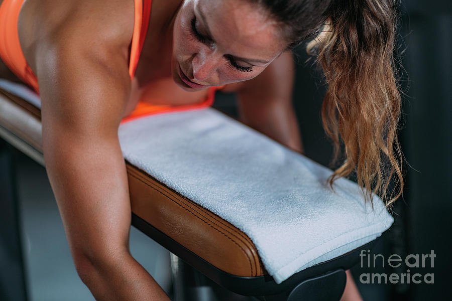 Female Athlete Using Lying Leg Curl Bench In The Gym #1 Photograph by Microgen Images/science Photo Library