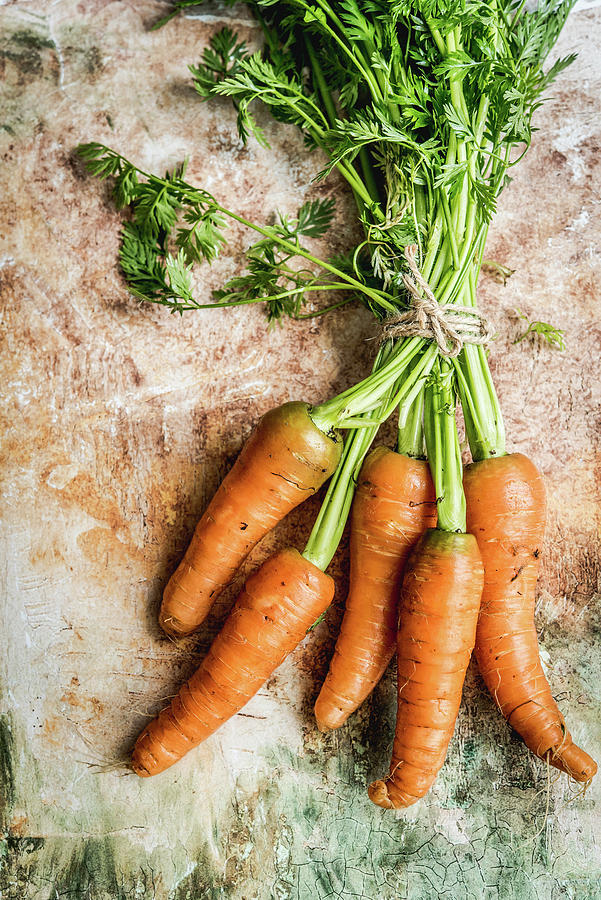 Fresh Carrots Moistened With Water On A Brown-green Background #1 Photograph by Diana Kowalczyk