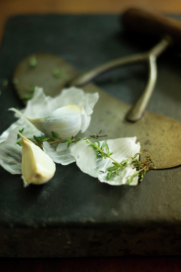 Garlic And Thyme On A Black Chopping Board #1 Photograph by Eising Studio