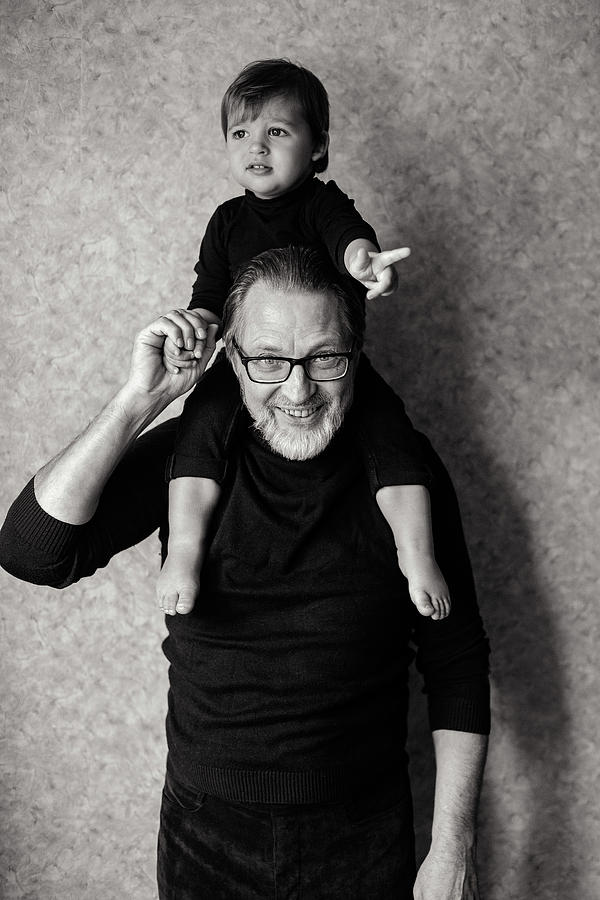 Grandfather With Beard And Glasses With His Grandson Sitting On The Neck Photograph