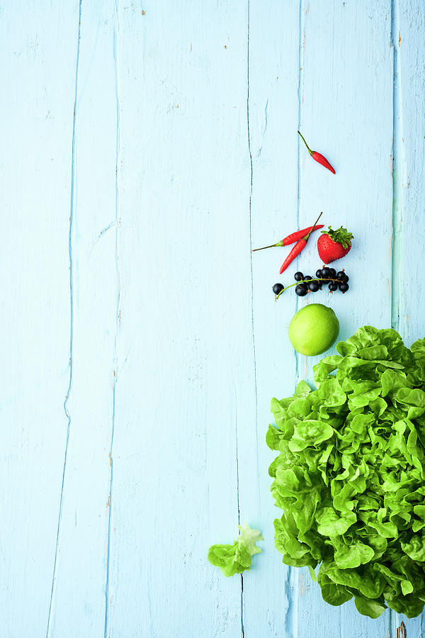Green Lettuce And Fruits On A Light Blue Wooden Surface #1 Photograph by Stockfood Studios / Andrea Thode Photography