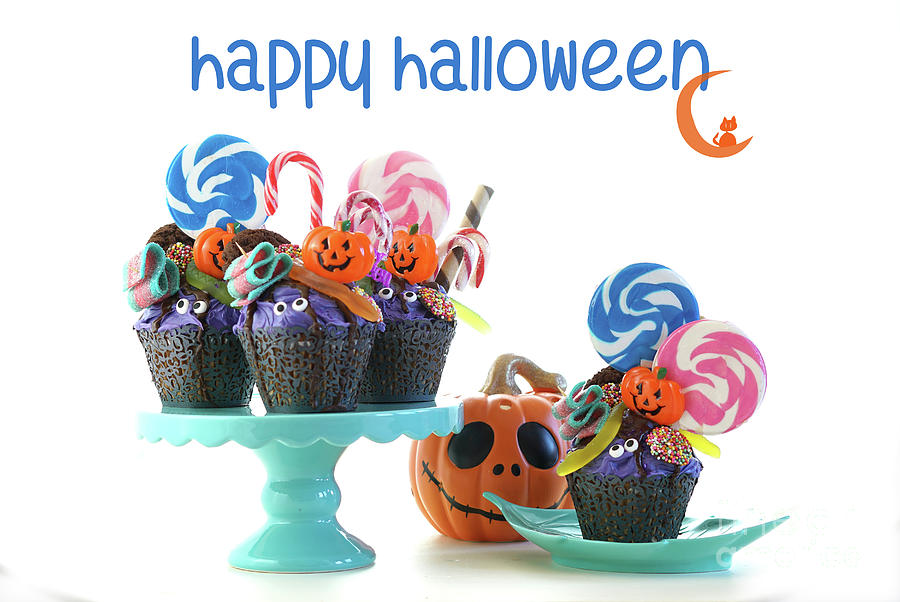 Halloween candyland drip cake style cupcakes with lollipops and candy on white. Photograph by Milleflore Images