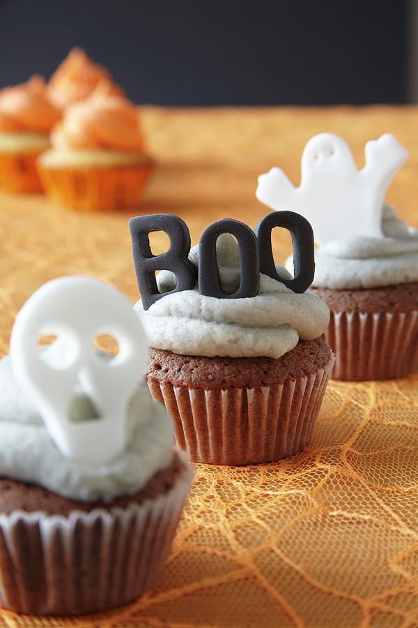 Halloween Cupcakes Decorated With Buttercream Icing And Spooky Cake Toppers #1 Photograph by Simon Scarboro