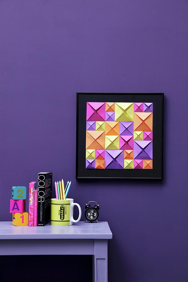 Hand-crafted, 3d-effect Artwork Made From Blue, Green And Purple Origami Squares Of Different Sizes On Violet Wall; Matching Ornaments On Desk #1 Photograph by Thordis Rggeberg