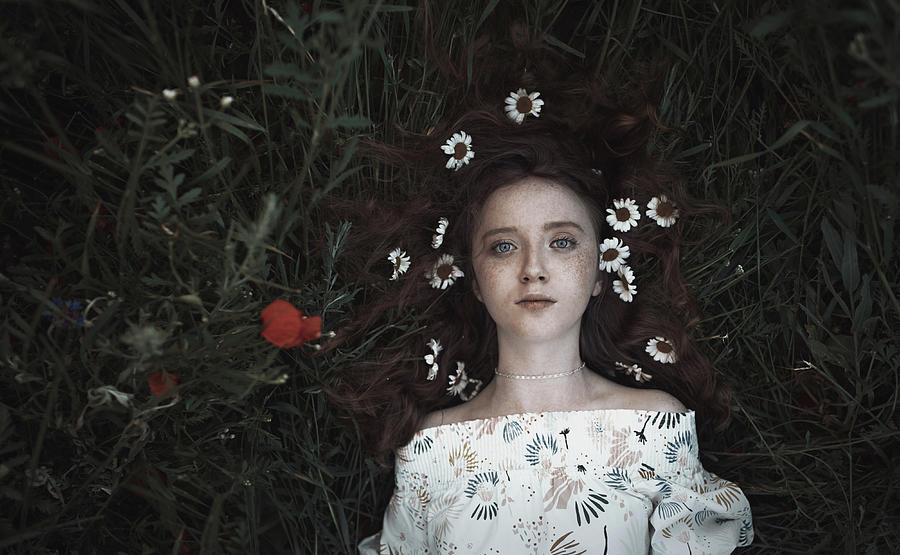 High Angle Portrait Of Teenage Girl With Flowers On Hair Lying On Field ...