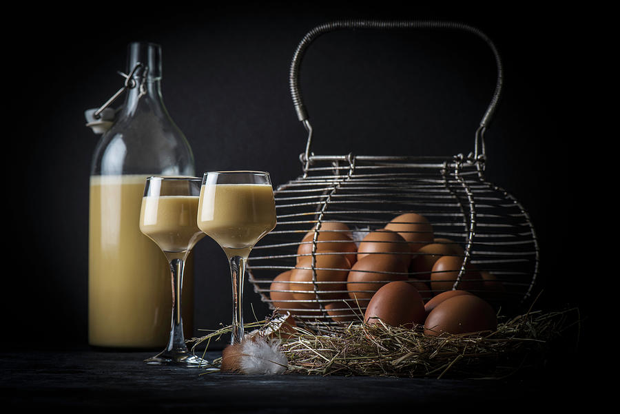 Homemade Egg Liqueur Next To An Old Wire Basket With Fresh Eggs On Straw #1 Photograph by Christian Kutschka