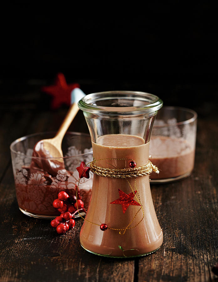 Homemade Gingerbread Liqueur In A Glass With Nut-nougat Cream Spread Behind It #1 Photograph by Teubner Foodfoto