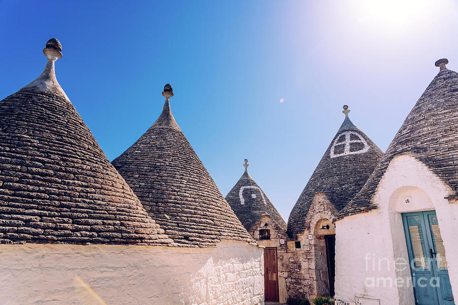 Houses of the tourist and famous Italian city of Alberobello, with its typical white walls and trulli conical roofs. #1 Photograph by Joaquin Corbalan