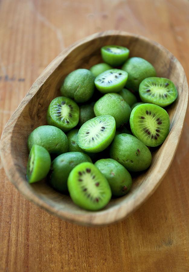 Kiwi Berries mini Kiwi In A Wooden Bowl On A Rustic Wooden Surface #1 Photograph by Ryla Campbell