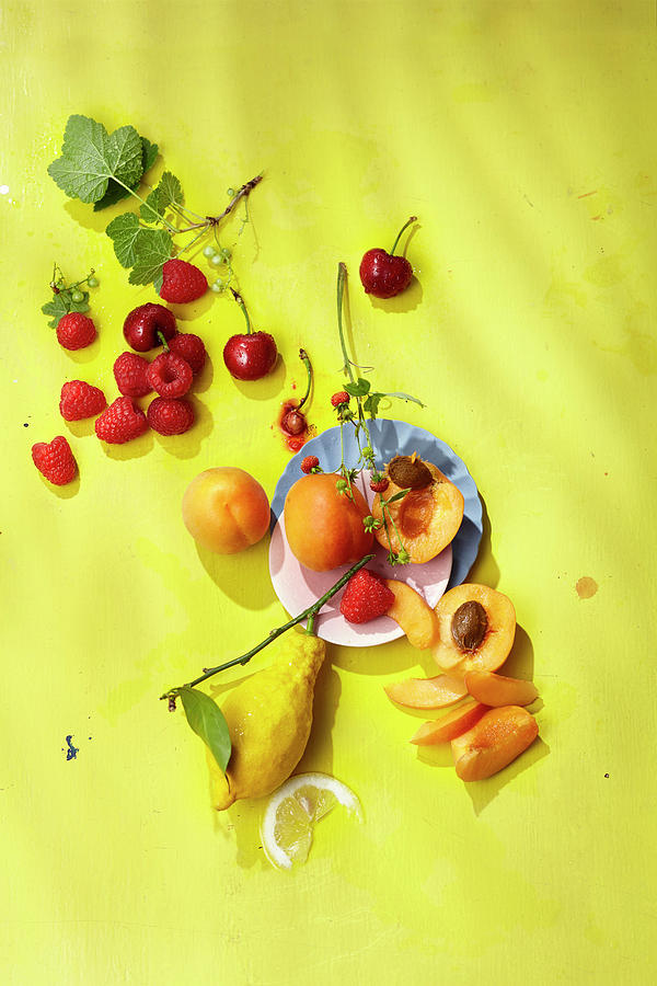 Lemons, Apricots And Fresh Berries On A Yellow Background #1 Photograph by Ulrike Stockfood Studios / Holsten