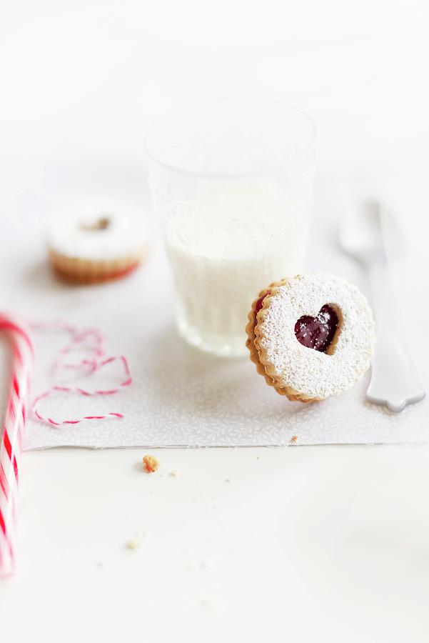 Linzer Augen nutty Shortcrust Jam Sandwich Biscuits With Holes On Top And A Glass Of Milk For Christmas #1 Photograph by Au Petit Gout Photography Llc