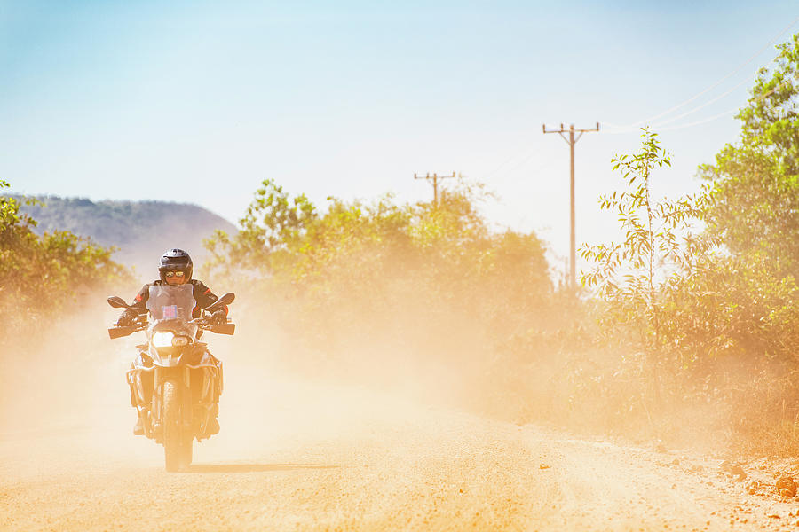 Sunset Photograph - Man Riding His Adventure Motorbike On Dusty Road In Cambodia #1 by Cavan Images