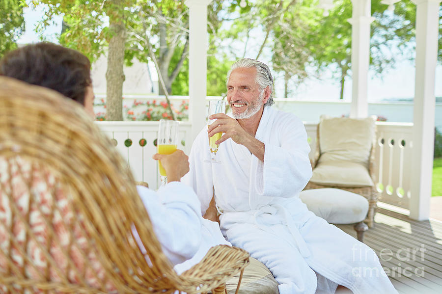 Bathrobe Photograph - Mature Couple In Spa Bathrobes Drinking Mimosas by Caia Image/science Photo Library Bathrobe Photograph - Mature Couple In Spa Bathrobes Drinking Mimosas by Caia Image/science Photo Library