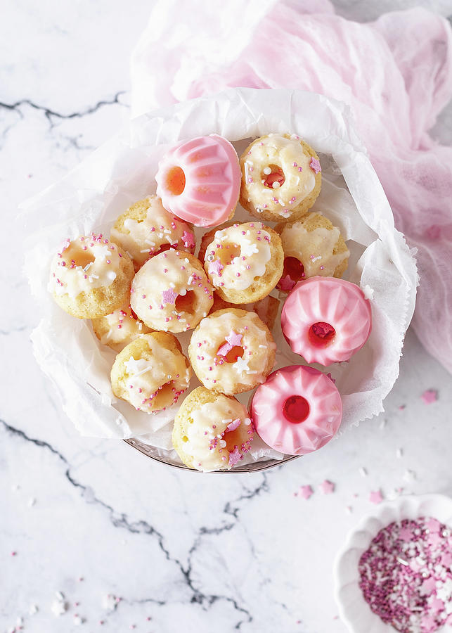 Mini Lemon And Yoghurt Bundt Cakes With Pink And White Icing #1 Photograph by Emma Friedrichs