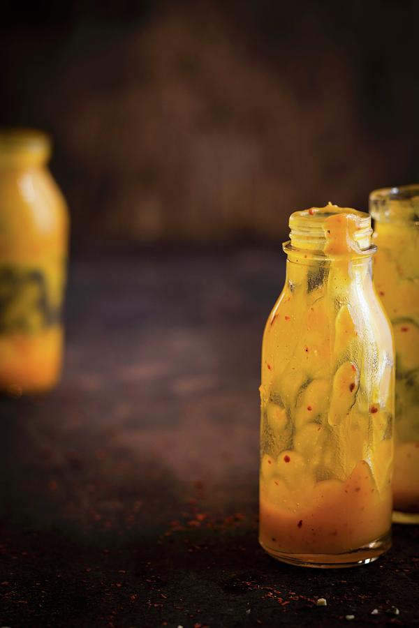 Nearly Empty Bottles Of Vegan Pumpkin Sauce With Chilli Peppers #1 Photograph by Eising Studio