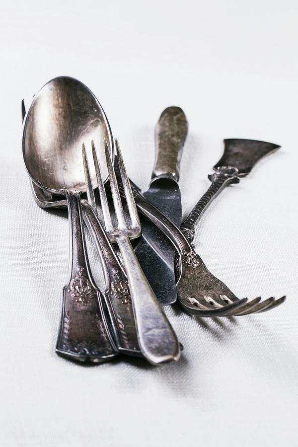 Old Silver Cutlery On A White Table Cloth #1 Photograph by Natasha Breen