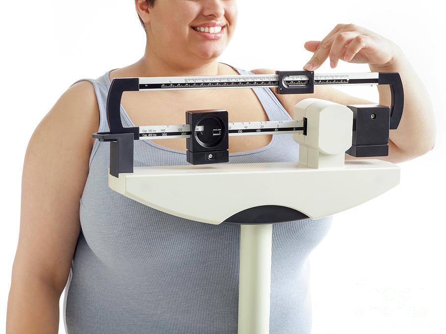 Overweight Woman Using Weighing Scales #1 Photograph by Science Photo Library