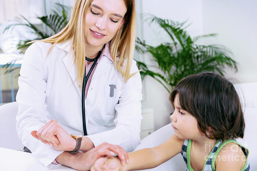 Paediatrician Measuring Boy's Heart Rate Photograph by Microgen Images ...