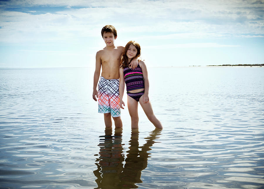 Nature Photograph - Portrait Of Brother Standing With Arm Around Sister On Sea Shore #1 by Cavan Images