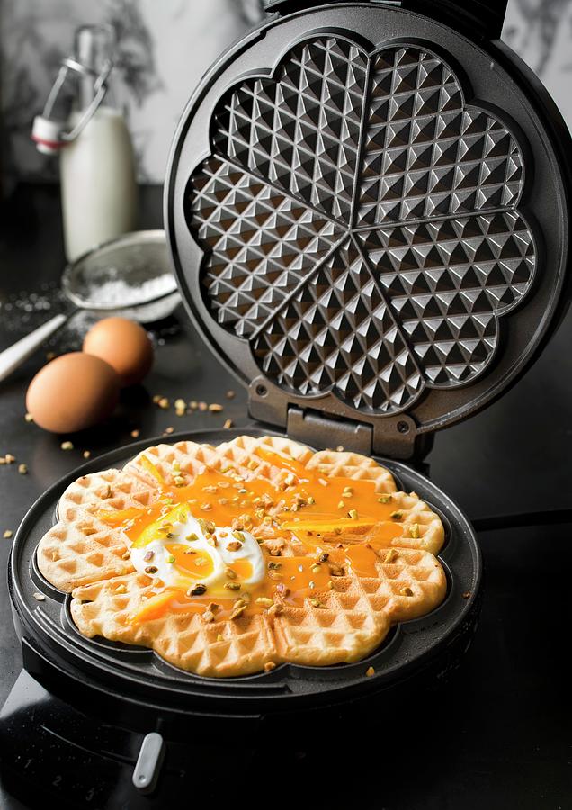 Preparing Waffles With Orange Coulis, Confit Orange Rinds And Pistachios #1 Photograph by Hallet