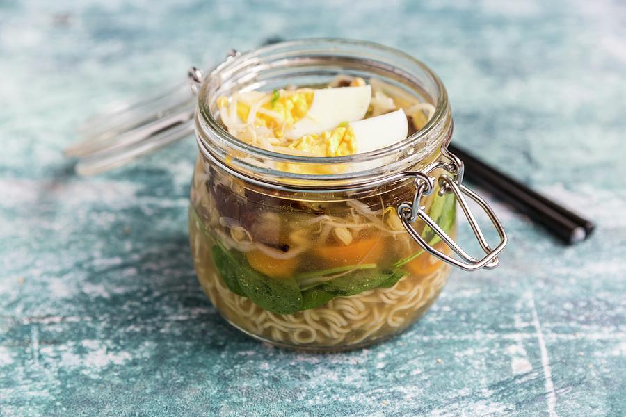 Ramen Soup With Spinach, Bamboo Shoots, Carrots, Egg And Mushrooms In A Glass Jar #1 Photograph by Sandra Rsch