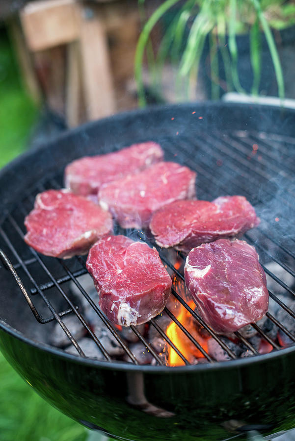 Raw Beef Loin Steaks On A Barbecue #1 Photograph by Sebastian Schollmeyer