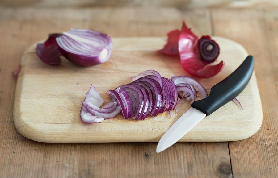 Red Onions, Sliced With A Knife On A Chopping Board #1 Photograph by Sonia Chatelain