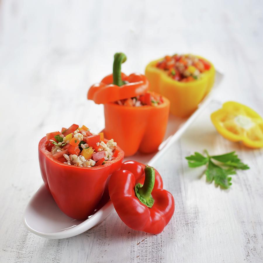 Red, Yellow And Orange Peppers Filled With A Rice, Pepper And Tomato Salad #1 Photograph by Mariola Streim