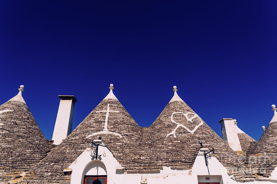 Roofs with symbols in the trulli, in the famous Italian city of Alberobello. #1 Photograph by Joaquin Corbalan